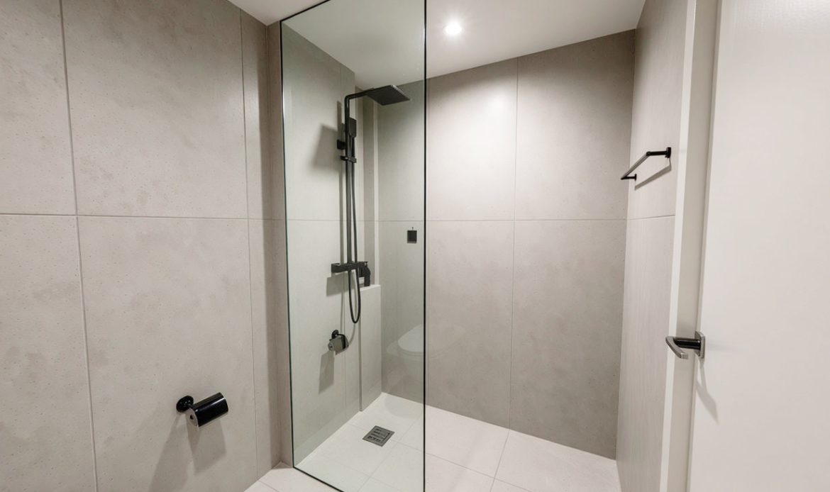 Contemporary tiled shower area with glass enclosure and modern fixtures
