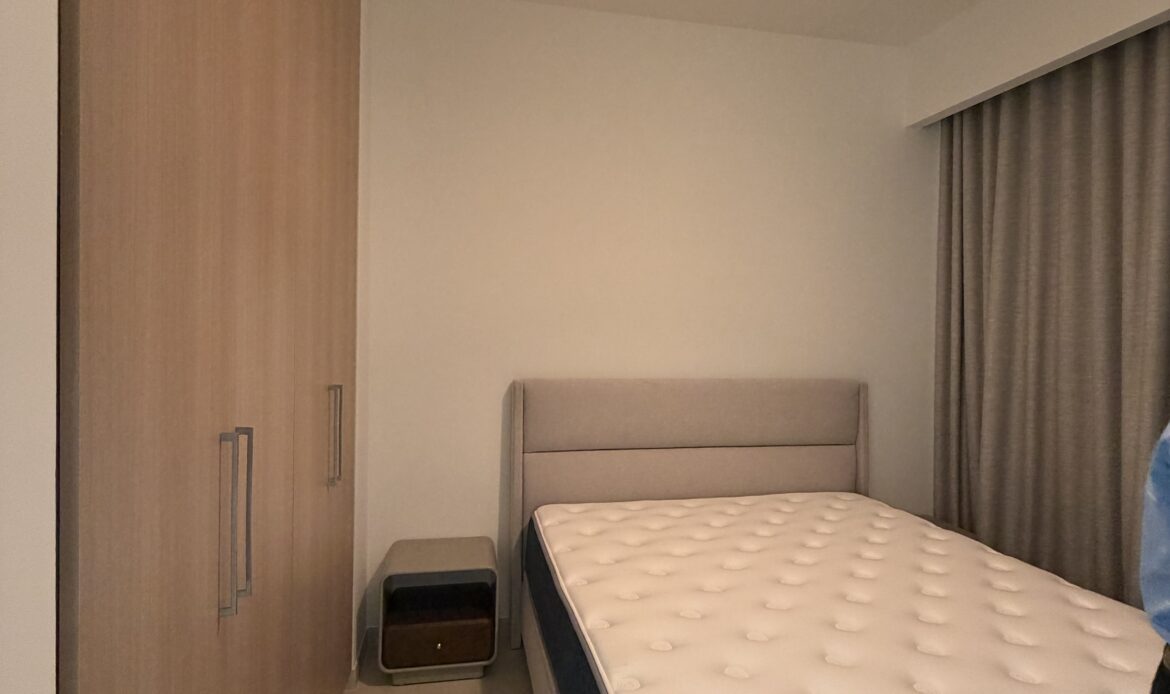 Bedroom with a bed, bedside table, and warm contemporary lighting