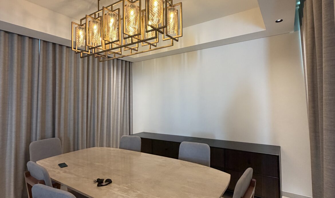 Dining area with a wooden dining table, chairs, and modern chandelier