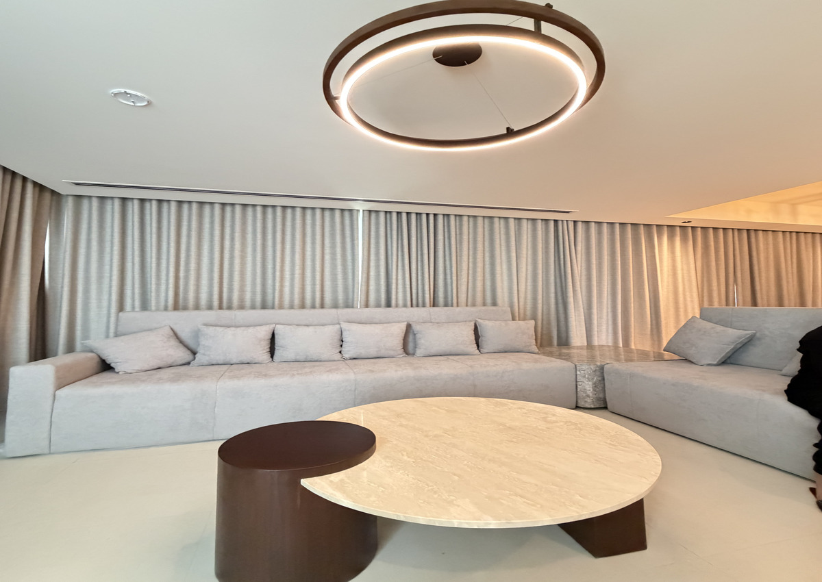 Modern living room featuring a curved sofa and round coffee table